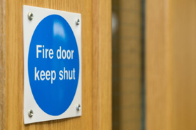A door with blue sign saying fire door keep shut